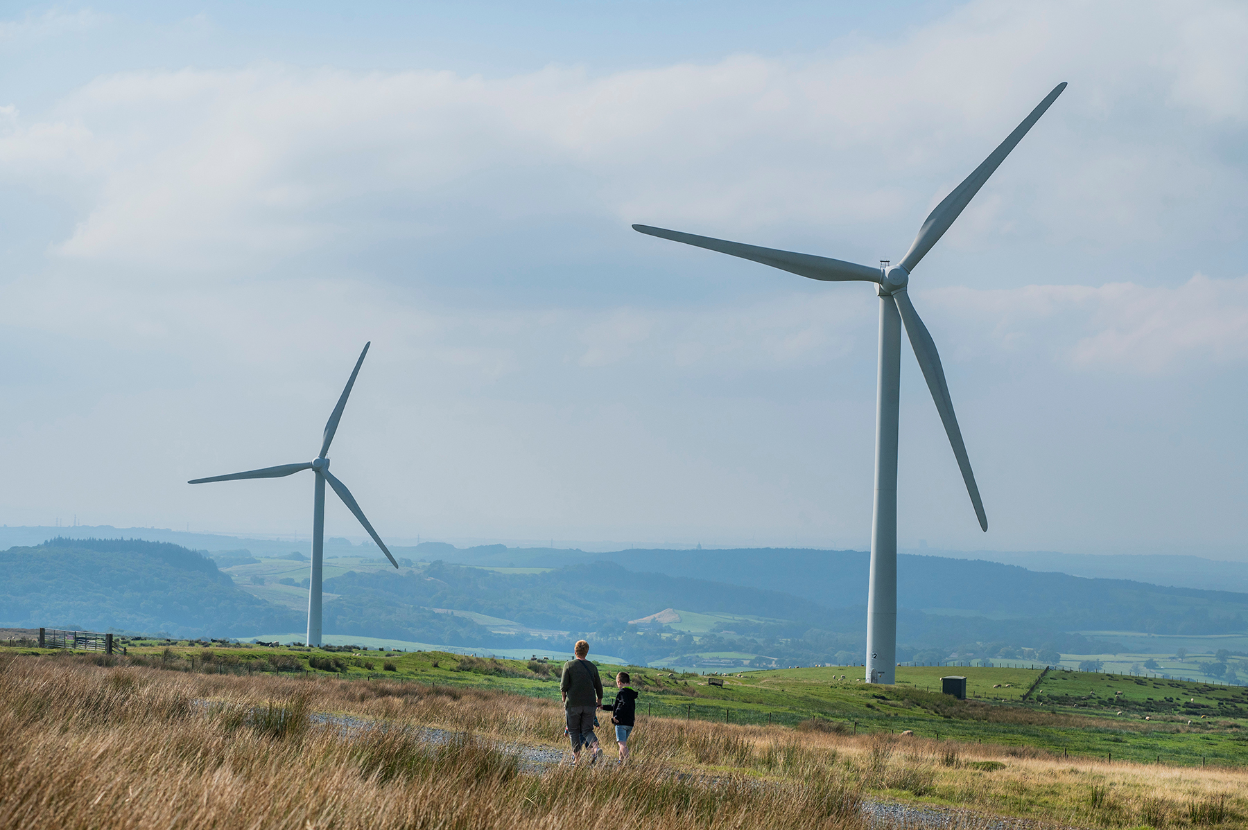 Adult and child walking around Thrive's Caton Moor wind farm at community open day