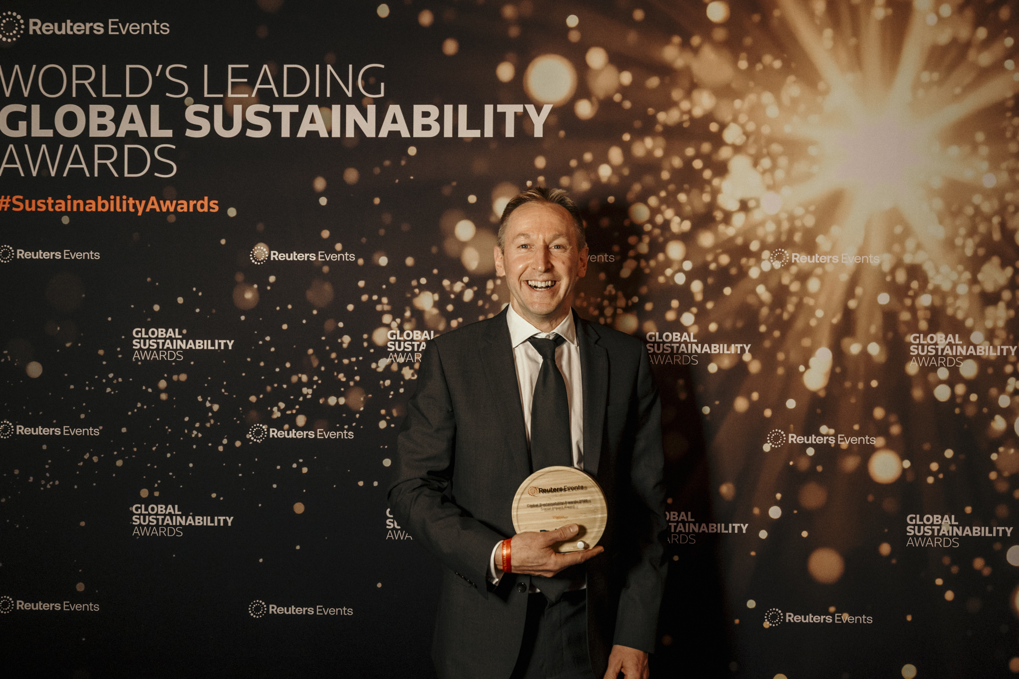 Thrive's CEO smiling and holding the award trophy for Responsible Investor of the Year at the Reuters Global Sustainability Awards